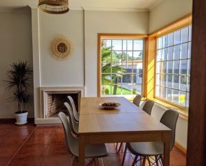 a dining room with a table and chairs and a fireplace at The Palm House in Ovar