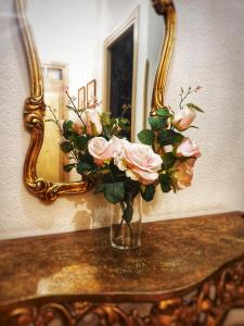 a vase of flowers on a table in front of a mirror at Casa de la Marina in Navas de Oro