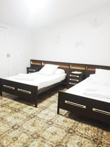 2 łóżka w pokoju z dywanem w obiekcie Casa de la Marina w mieście Navas de Oro