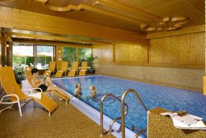 a swimming pool with two people in a hotel at Appartement Kristall in Zell am See