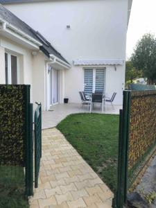 einen Zaun vor einem Haus mit einer Terrasse in der Unterkunft Gîte vickie in Livry