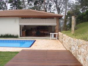 Un patio trasero con piscina y una casa. en Chácara em Atibaia, en Atibaia