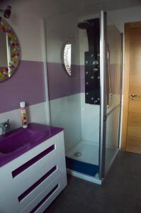 La salle de bains est pourvue d'un lavabo violet et d'une douche. dans l'établissement La casa de Jesús Llandres, à Husillos