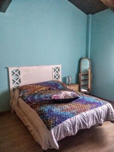 a bedroom with a bed in a blue wall at La casa de Jesús Llandres in Husillos
