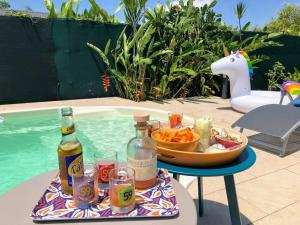 a tray of food and drinks on a table next to a pool at Villa Ohana in Sainte-Anne +25 photos