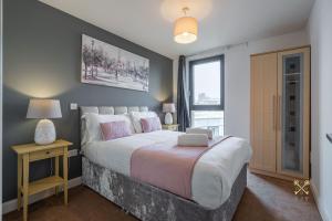 a bedroom with a large bed and a window at Arcadian City Centre Apartment in Birmingham