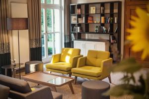 a living room with two yellow chairs and a table at Landgut Stemmen in Stemmen