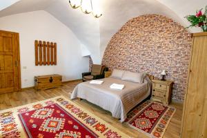 a bedroom with a bed and a brick wall at Rosenthal House in Sighişoara