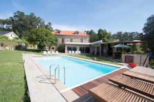 una piscina con sillas y una casa en Quinta da Devesa, en Valença