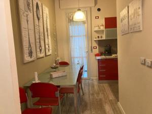 ヴィアレッジョにあるconfort homeのキッチン(ダイニングルームテーブル、赤い椅子付)