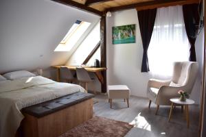 a bedroom with a bed and a desk and windows at House Boro in Jezerce