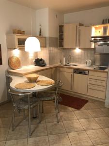 una cucina con tavolo e sedie e una cucina con lavandino di Apartament BURSZTYN a Kołobrzeg