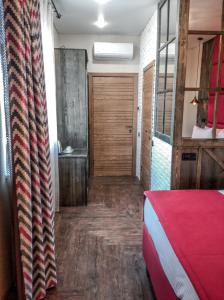 エッセントゥキにあるTermanly Aqua Hotelのベッド1台と木製のドアが備わる客室です。