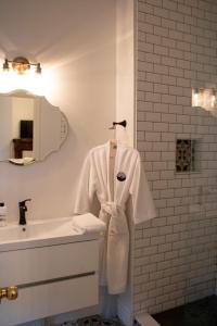 a bathroom with a robe hanging on a sink at The Secret Garden Inn in Kingston