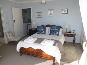 ein Schlafzimmer mit einem großen Bett mit blauen Kissen in der Unterkunft No. 1 Living Waters in Simonʼs Town