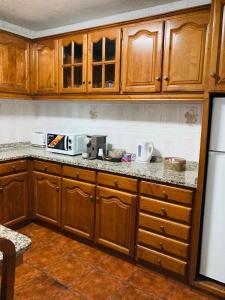 a kitchen with wooden cabinets and a counter top at Casa de Ferias no Gerês in Ferral