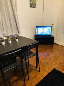 a table with two chairs and a television in a room at Casa de Ferias no Gerês in Ferral