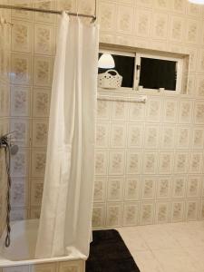 a bathroom with a shower with a white shower curtain at Casa de Ferias no Gerês in Ferral