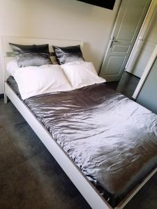 Una cama con sábanas blancas y almohadas. en Design Standing Apt in Aix, en Aix-en-Provence