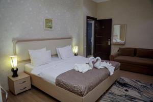 Un dormitorio con una cama con dos cisnes. en Rustaveli Palace en Tiflis