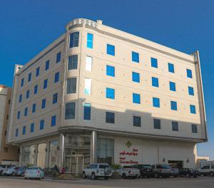 a large building with blue windows in a parking lot at Royal Golden House in Dammam