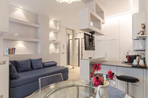 un soggiorno con un divano blu e una cucina di Residenza l'oasi a Bologna