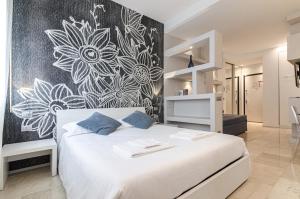 una camera da letto con un letto bianco e un murale floreale di Residenza l'oasi a Bologna Altre 12 foto
