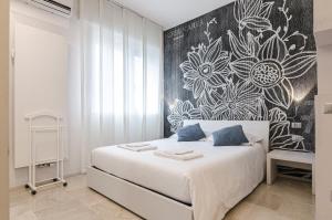 una camera da letto con un letto bianco e un murale floreale sul muro di Residenza l'oasi a Bologna