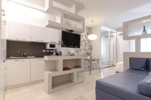 una cucina e un soggiorno con armadi bianchi e divano di Residenza l'oasi a Bologna