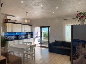 eine Küche und ein Wohnzimmer mit einem Tisch und einer Couch in der Unterkunft Guest House Costa 1 in Karianí