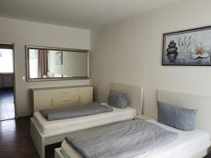 a bedroom with two twin beds and a mirror at New City Center Stays 1 in Munich