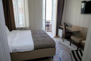 um quarto com uma cama, uma secretária e uma janela em Rustaveli Palace em Tbilisi