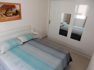 a small bedroom with a bed and a mirror at Apto 501 O conforto de sua casa na praia do morro in Guarapari