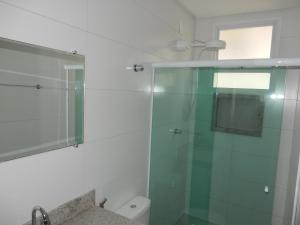 a bathroom with a glass shower and a toilet at Apto 501 O conforto de sua casa na praia do morro in Guarapari +70 photos