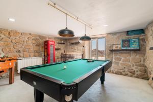 uma mesa de bilhar num quarto com paredes de pedra em Casa de Lagarinhos JACUZZI SPA JOGOS GYM - SERRA DA ESTRELA - SEIA - GOUVEIA em Gouveia