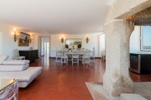 uma grande sala de estar com mesa e cadeiras em Casa de Lagarinhos JACUZZI SPA JOGOS GYM - SERRA DA ESTRELA - SEIA - GOUVEIA em Gouveia