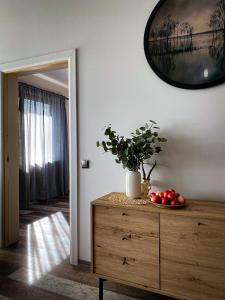 a room with a wooden dresser with a plant on a dresser at Estate Holiday home in Kuldīga