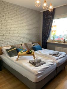 a large bed with a tray of fruit on it at Tarnovia Loft Apartment in Tarnowo Podgórne