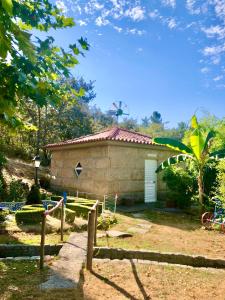 a small house with a windmill in the background at Chambre de la tour - Quinta da Prelada Simão in Celorico de Basto