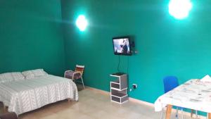 a bedroom with a bed and a tv on a wall at Complejo Berazategui in Villa D. Sobral