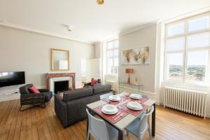 a living room with a table and chairs at Le Rempart du Midi in Angoulême