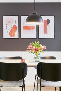 a dining room table with chairs and a vase of flowers at Glücksferien- Löwenzahn in Glücksburg