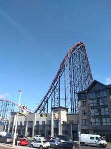 a roller coaster in a parking lot next to a building at Sea-front Apartment home-from-home in Blackpool