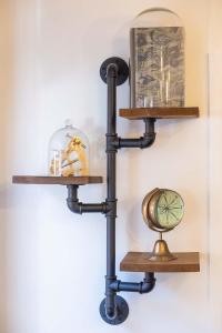 a black pipe shelf with a clock on a wall at Stunning- The Nautilus Bungalow Cowes IOW in Cowes