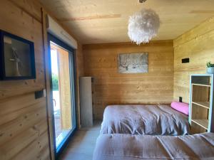 - une chambre avec un lit dans une pièce en bois dans l'établissement L'ADRET DU TEMPS CHALET 10 PERSONNES 170m2, à Gérardmer