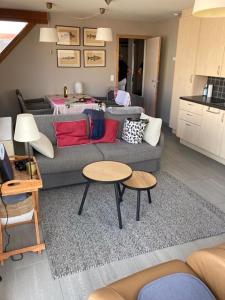 a living room with a couch and two tables at Zonnig appartement in Nieuwpoort