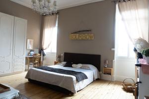 a bedroom with a bed and a chandelier at Vanille Bourbon in Montauban