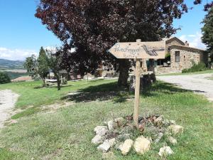 a sign in the grass in front of a building at La Moiana 1756 in Castiglione dʼOrcia