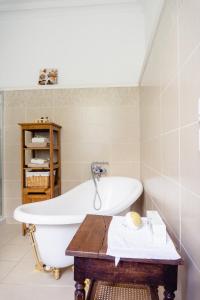 a bath tub in a bathroom with a wooden table at Vanille Bourbon in Montauban