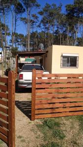 una recinzione di legno di fronte a una casa con un'auto di Casa Ocean Park - Brothers a Ocean Park